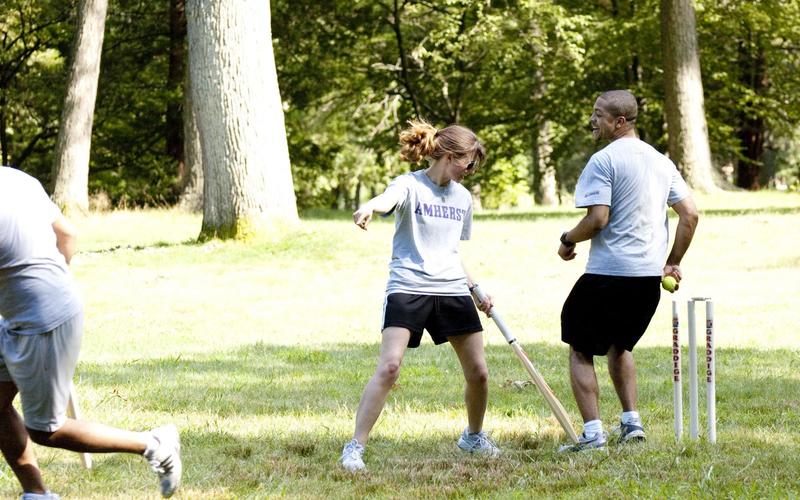 Students running toward one another during a cricket match