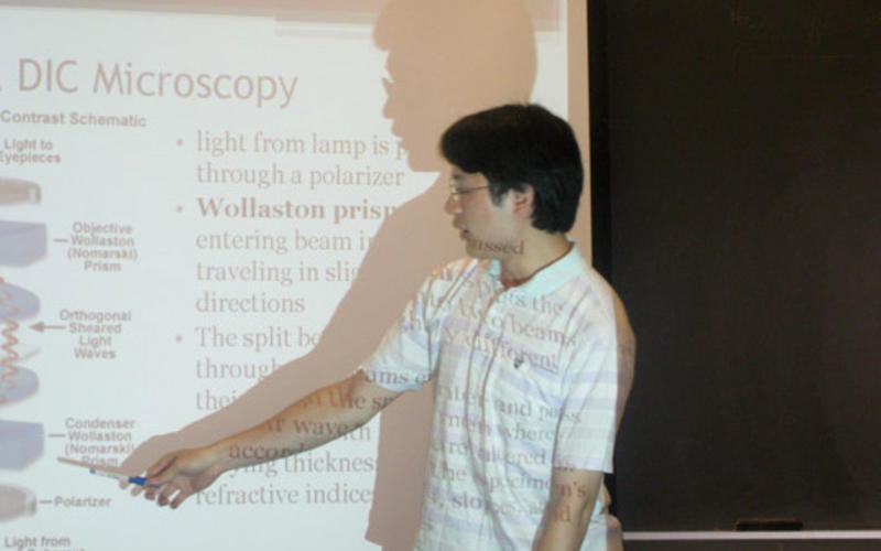 Undergraduate pointing at slide during his talk