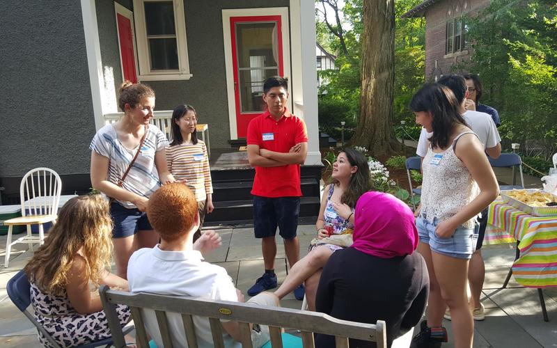 Group of people talking while standing in a circle outside