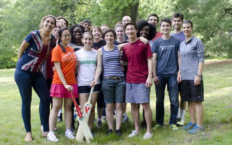 REU students and leadership group in athletic clothes holding cricket bats