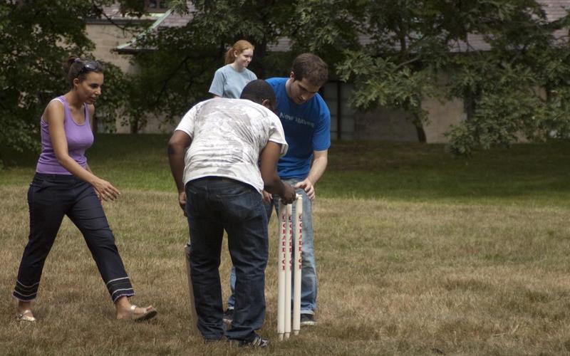 Two students fix a cricket set-up