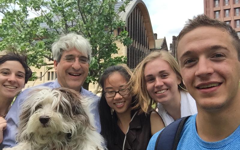 Selfie of REU students with Peter Salovey and a small fluffy dog