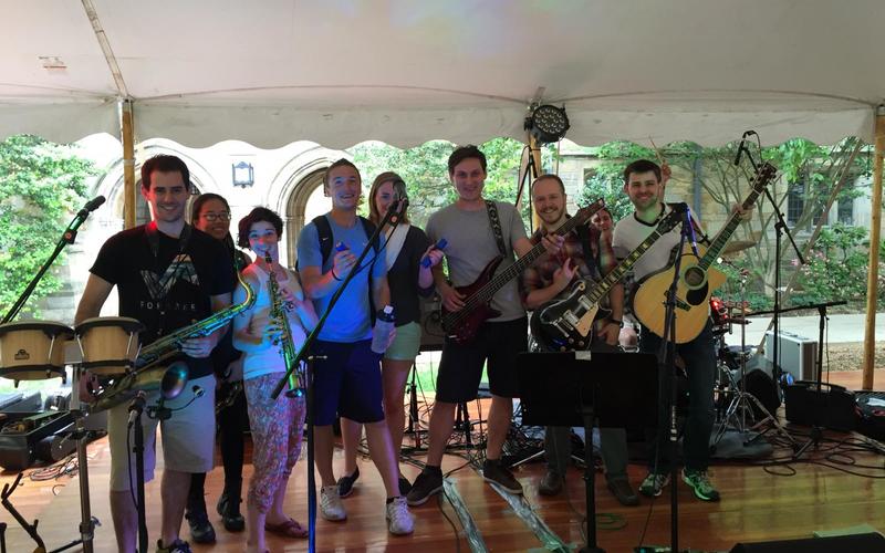 Large group of REU students holding a variety of musical instruments