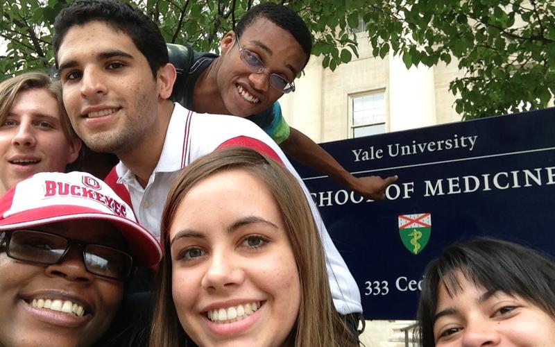 Selfie of 5 REU students in front of the sign for the Yale School of Medicine