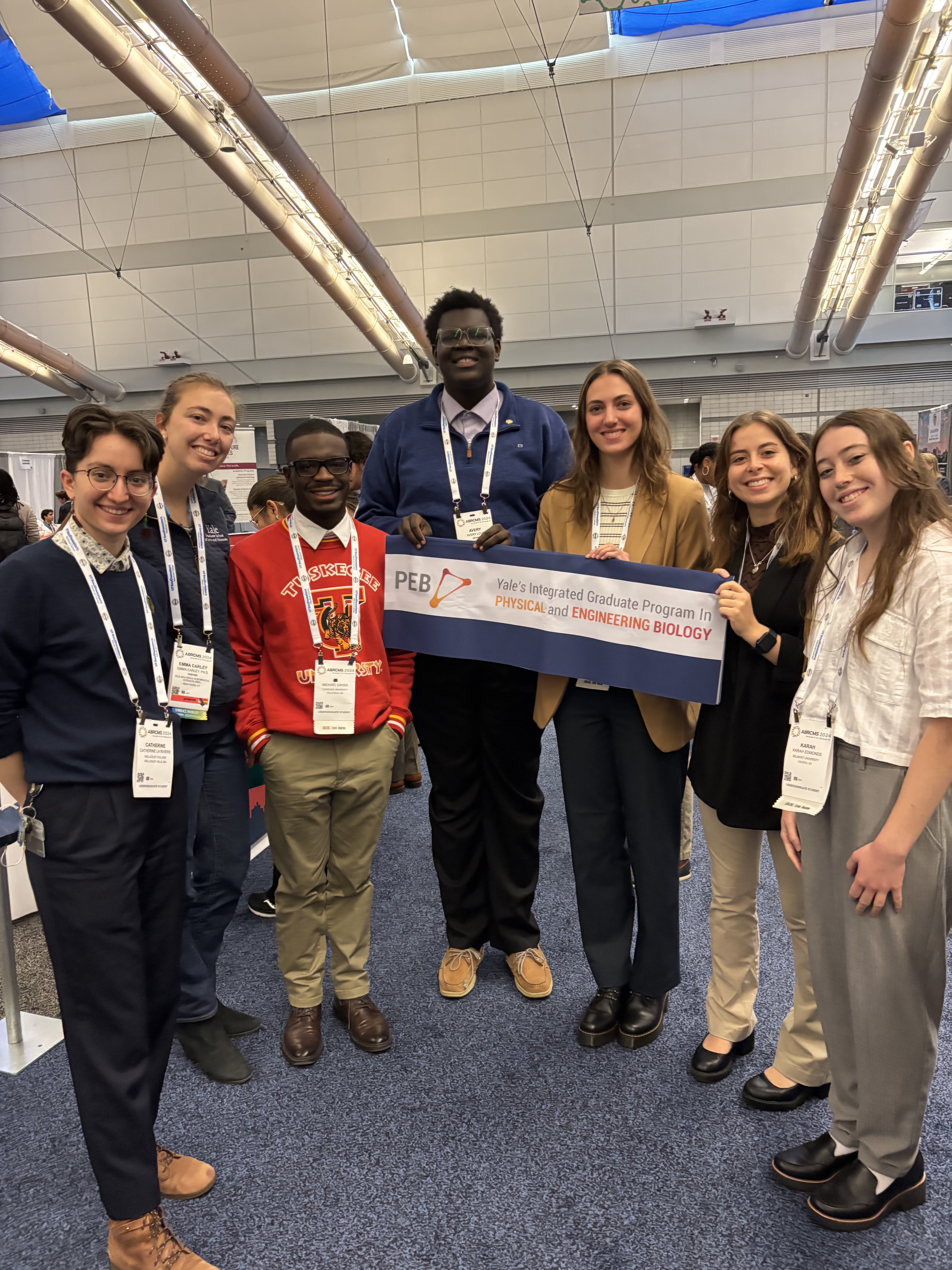 Group photo of PEB REU alumni holding the PEB banner