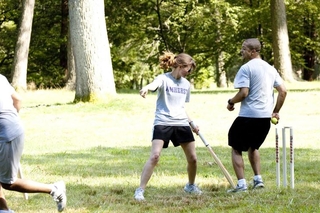 Students running toward one another during a cricket match