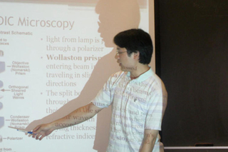 Undergraduate pointing at slide during his talk