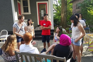 Group of people talking while standing in a circle outside