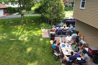 Two groups of people sitting around large tables in a backyard