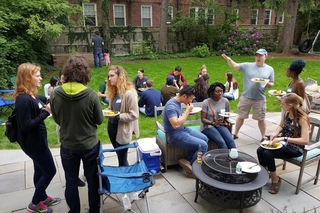 Several groups of people talking casually in a backyard