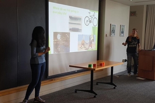 Two students standing in front of their powerpoint presentation 