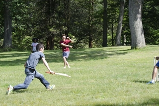 Students running toward one another during a cricket match