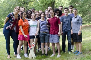 REU students and leadership group in athletic clothes holding cricket bats