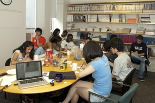 Students sitting around a large table talking with one another during a group activity