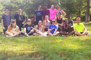 Group of REU students in athletic attire holding cricket bats