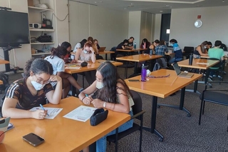 Several pairs of REU students discuss an activity