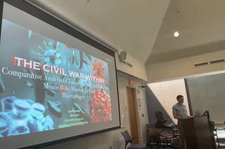 Jacob standing in front of his research powerpoint