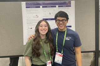 Lam and Karah standing in front of Karah's poster