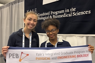 Emma and Latavia holding a PEB banner