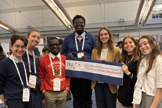 Group photo of PEB REU alumni holding the PEB banner