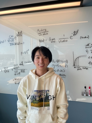 Daiyao standing in front of a white board